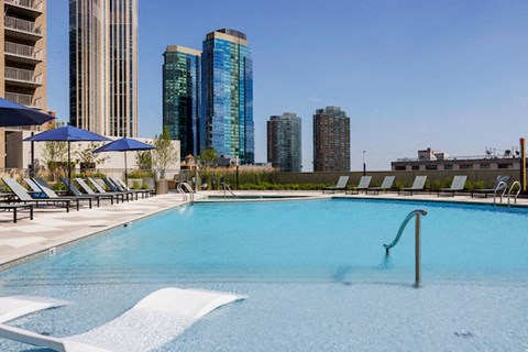 A swimming pool with a city skyline in the background.