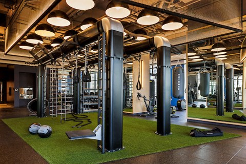 A gym with a variety of equipment including a weight machine, a ladder, and a bench.