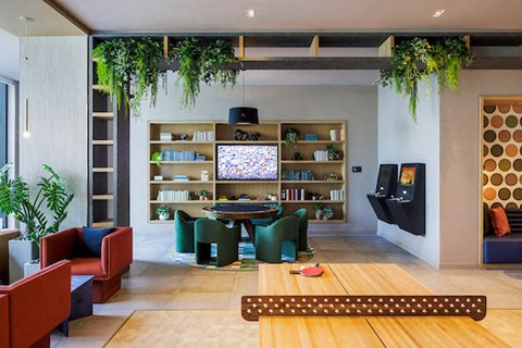 A living room with a wooden floor and a large bookshelf filled with books.