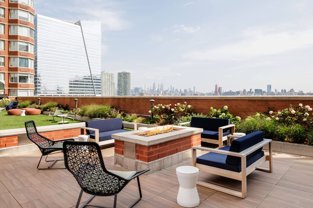 A patio with a table and chairs overlooking a city skyline.
