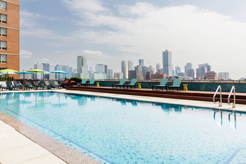 A swimming pool with a city skyline in the background.