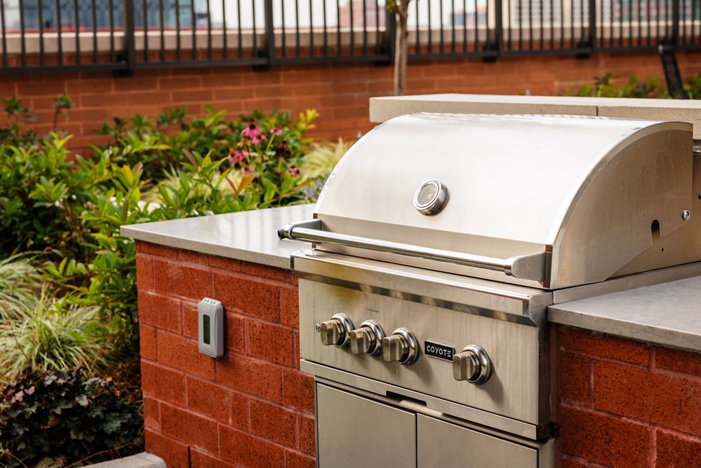 A brick wall with a grill on top of it.