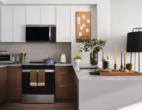 A modern kitchen with a black oven and wooden cabinets.