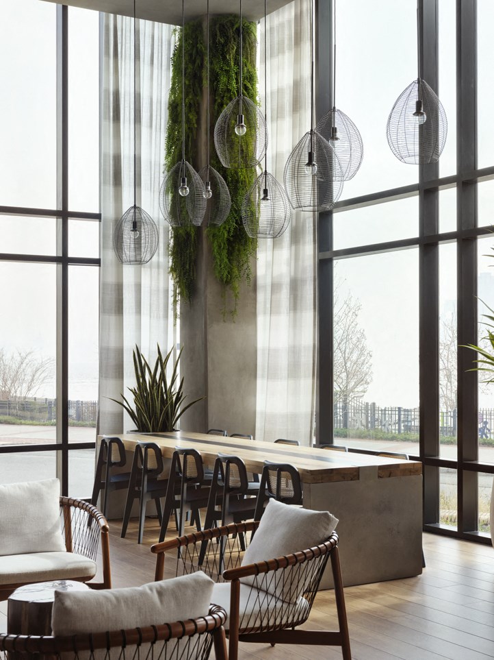 a living room with a table and chairs and large windows