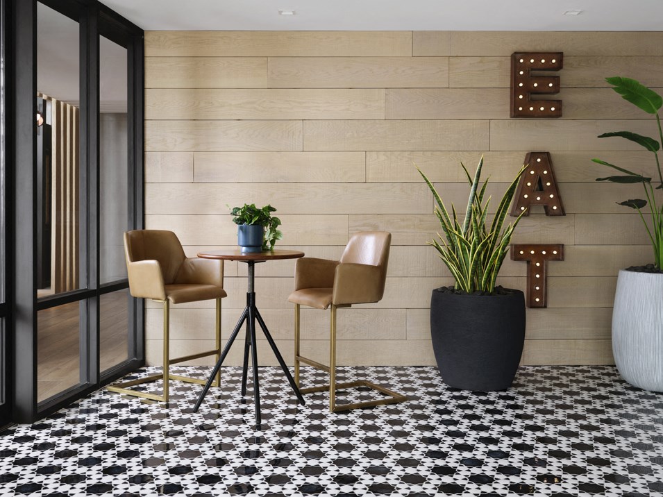 a dining area with two chairs and a table with plants