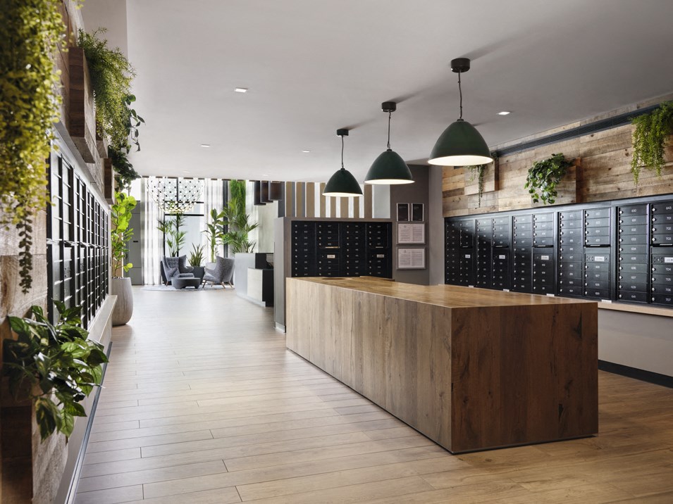 the lobby of a restaurant with a wooden counter top and plants on the wall