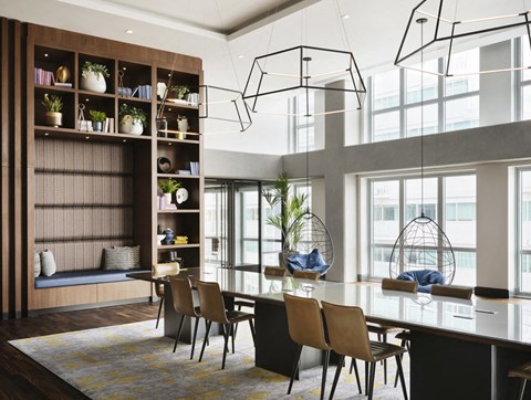 a dining room with a glass table and chairs and a large window