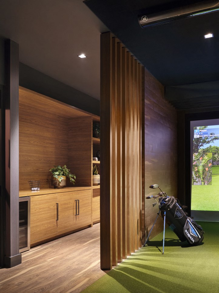 a golf room with a green carpet and a golf club in it