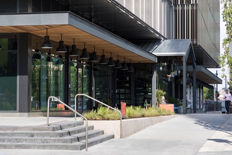 A modern building with a glass facade and a metal roof.