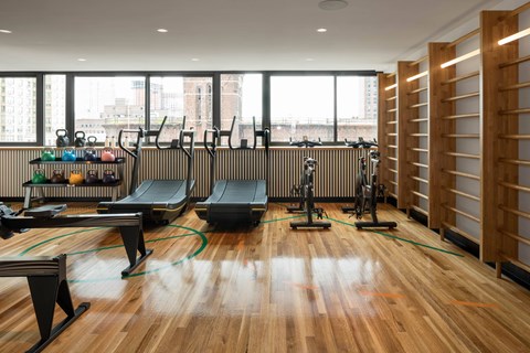 A gym with treadmills, exercise bikes, and other equipment.