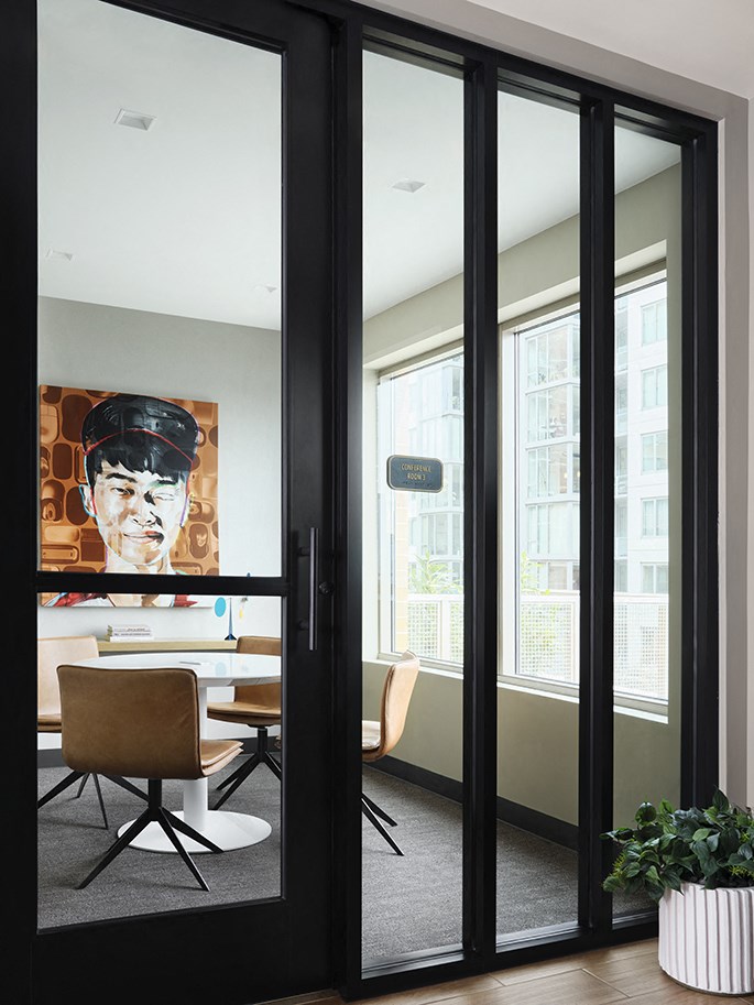 a room with a table and chairs and a painting on the wall