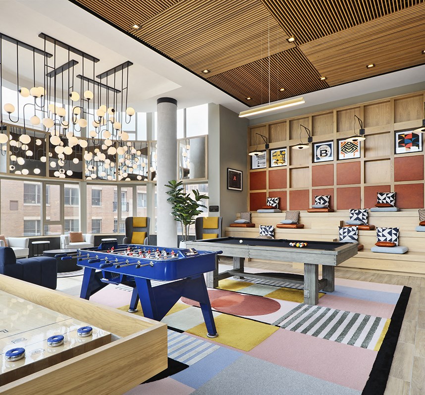 a communal area with a ping pong table in the lobby of a hotel