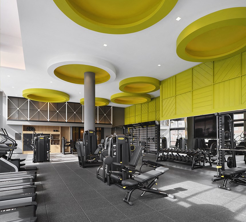 a gym with weights machines and yellow ceilings