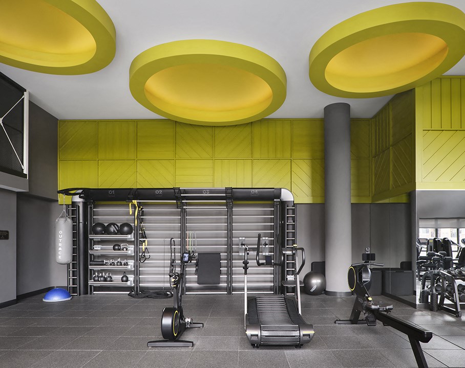 a gym with yellow ceilings and gym equipment