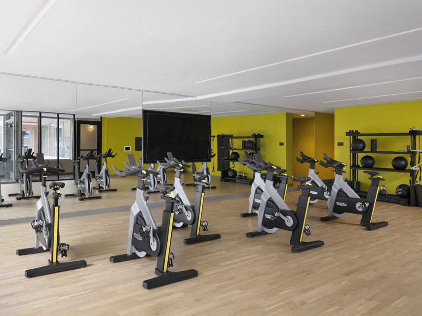 a reformer bike class room in a gym with yellow walls