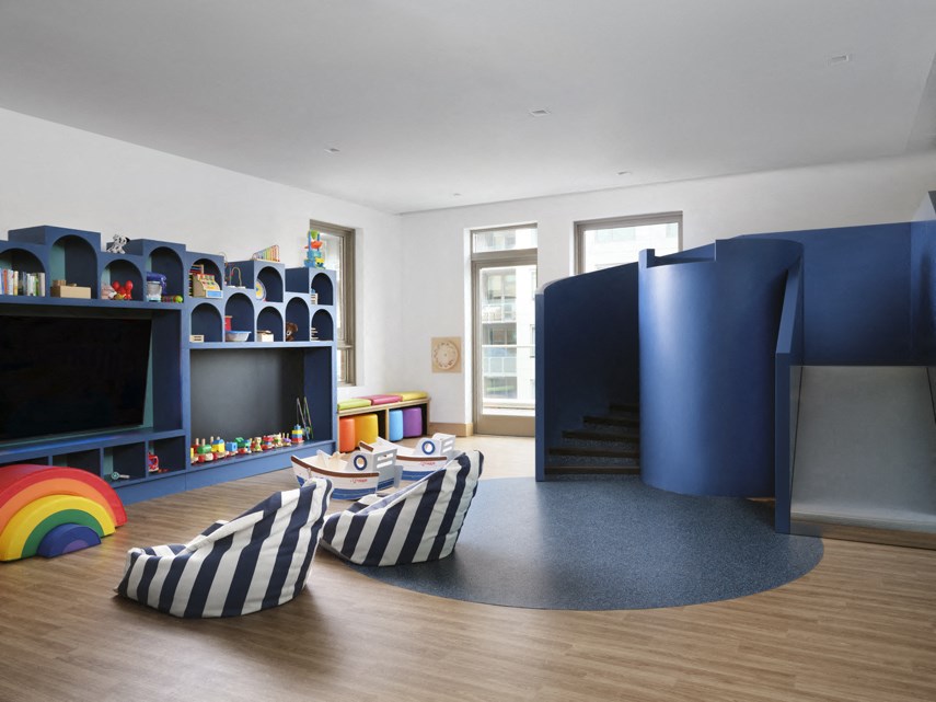 a living room with blue furniture and a play area