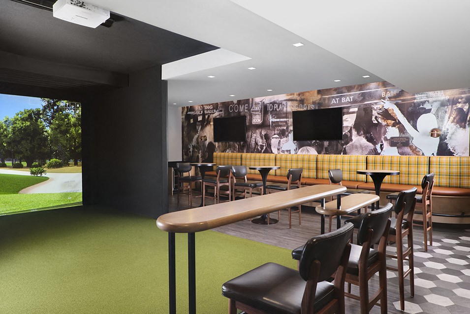 a bar with tables and chairs and a mural on the wall