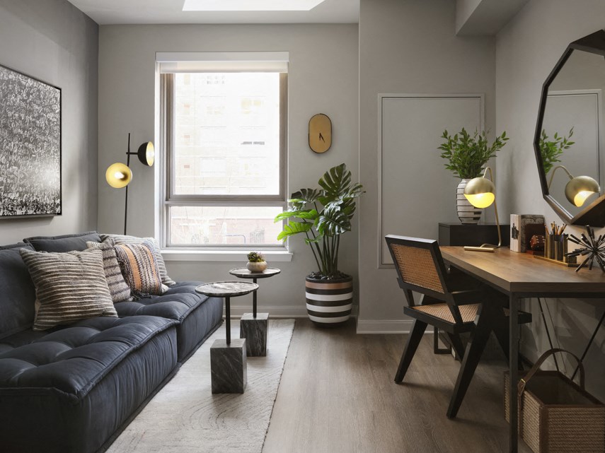 a living room with a blue couch and a table and a window