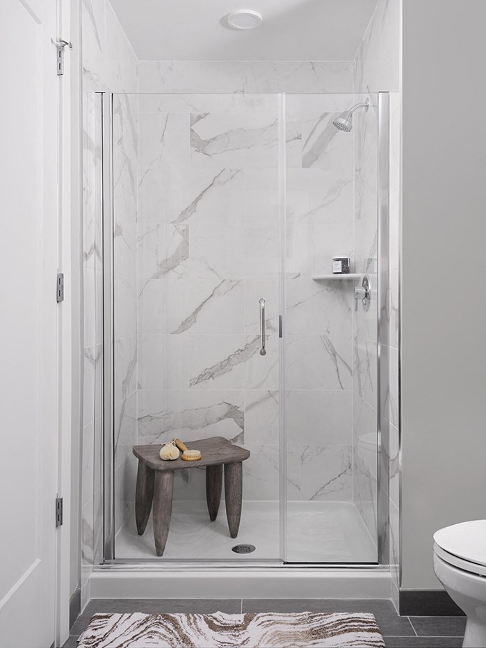a bathroom with a shower and a stool in it