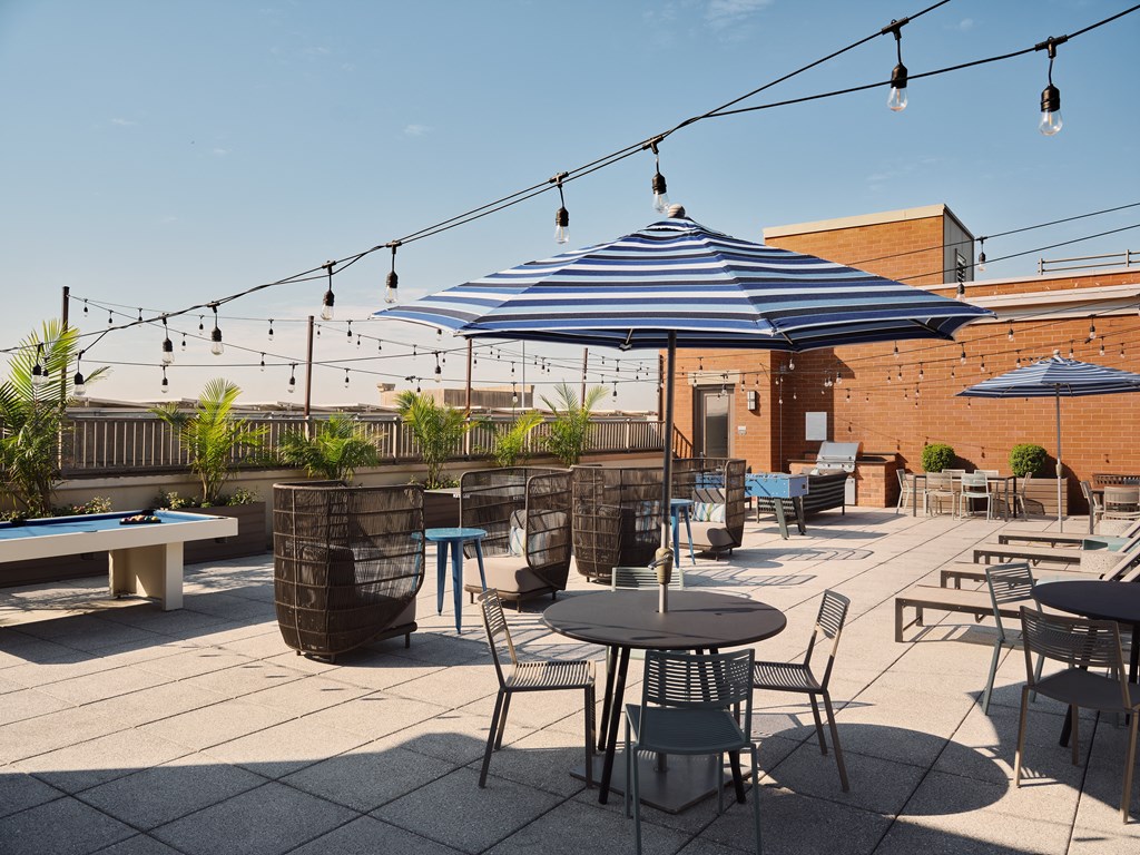 a patio with tables and chairs and umbrellas on a roof