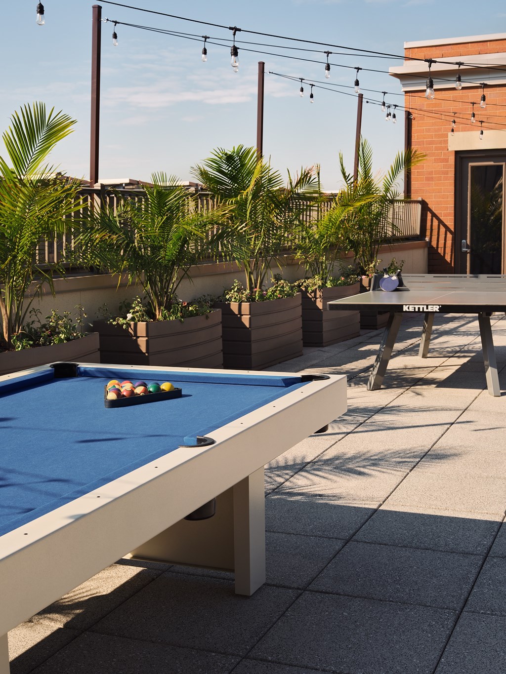 a pool table on a patio with tables and plants