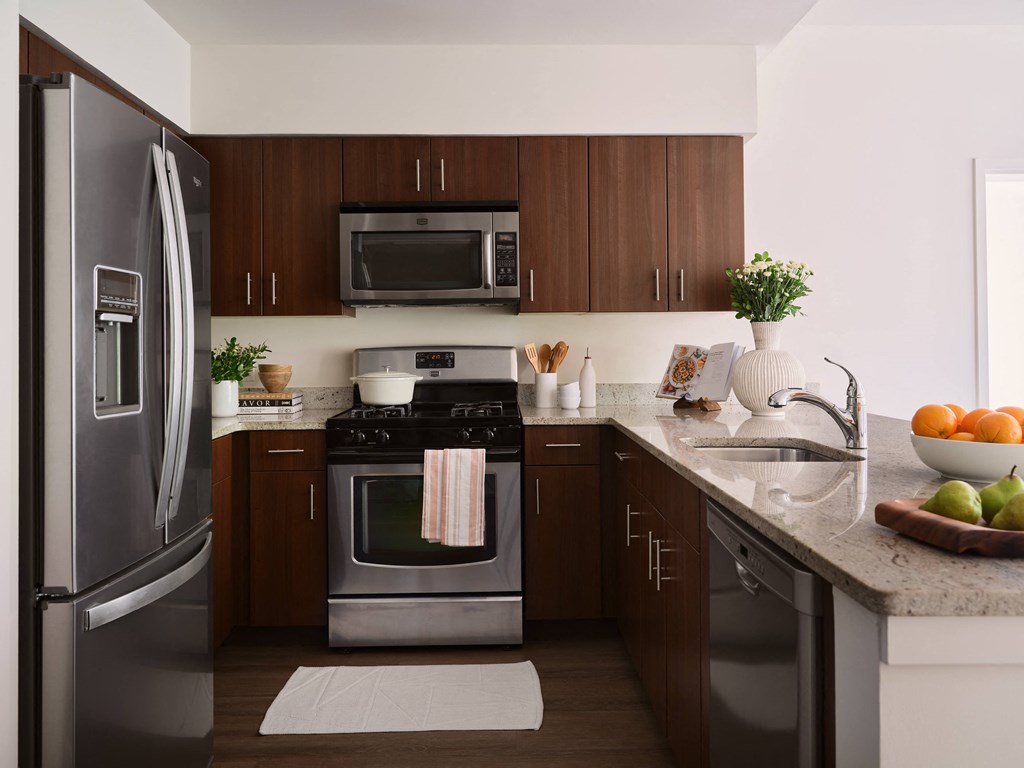 a kitchen with stainless steel appliances and a marble counter top