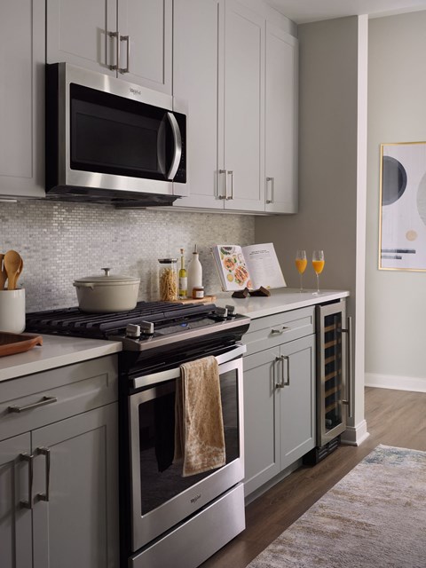a kitchen with white cabinets and a stove and a microwave