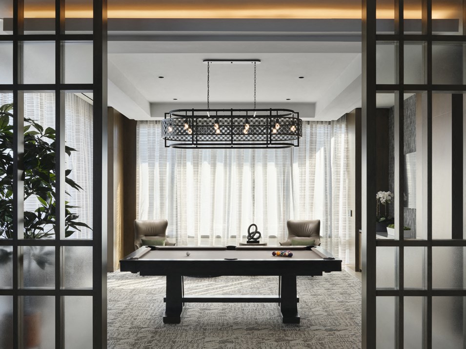 a living room with a pool table and a large window
