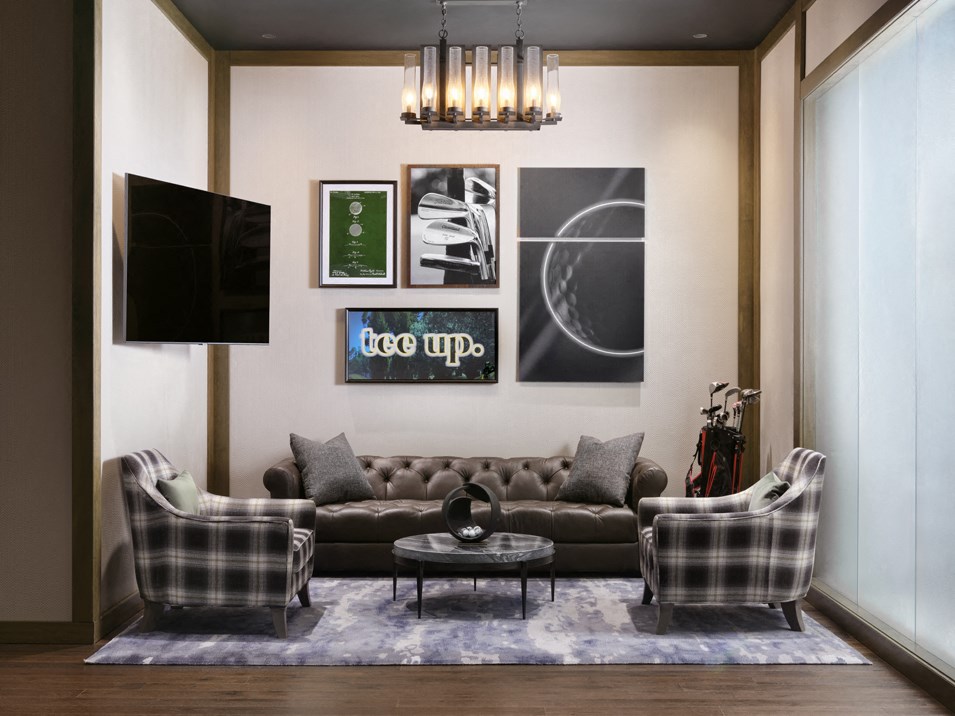 a living room with a couch and two chairs and a chandelier