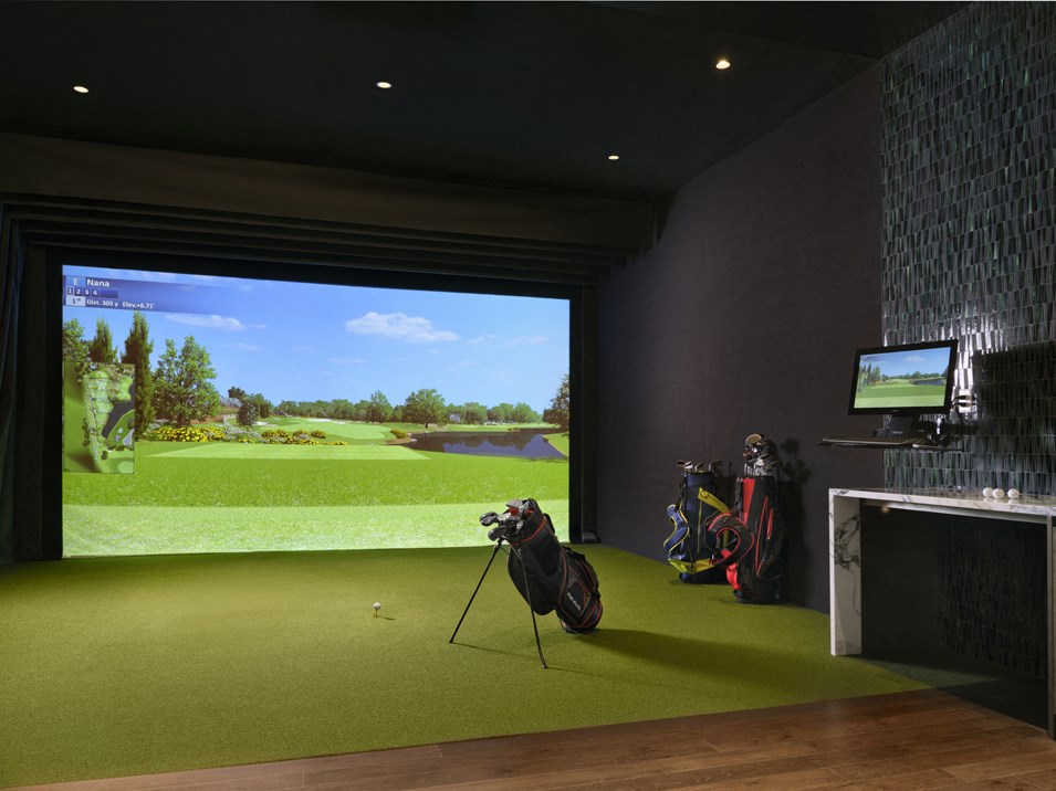 a golf simulator with a view of a golf course in a room