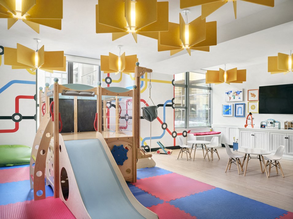 a childrens play room with a slide and a table and chairs