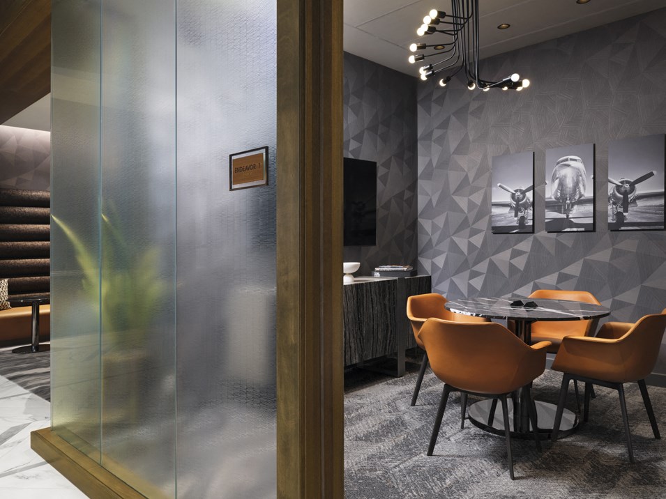 a conference room with a glass door and a table with chairs