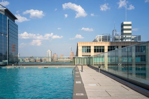 A glass building with a pool in front.