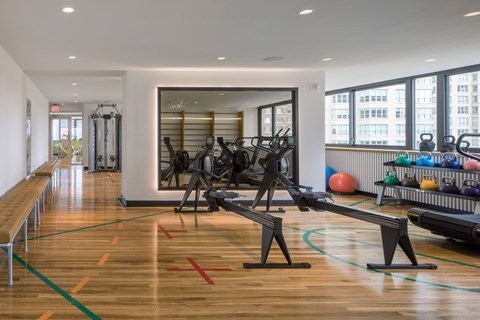 A gym with a row of exercise bikes and a row of exercise machines.