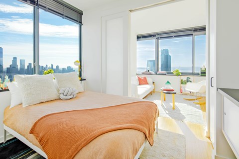 A bedroom with a large bed and a view of the city.