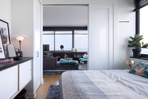 A bedroom with a bed, a couch, and a window.