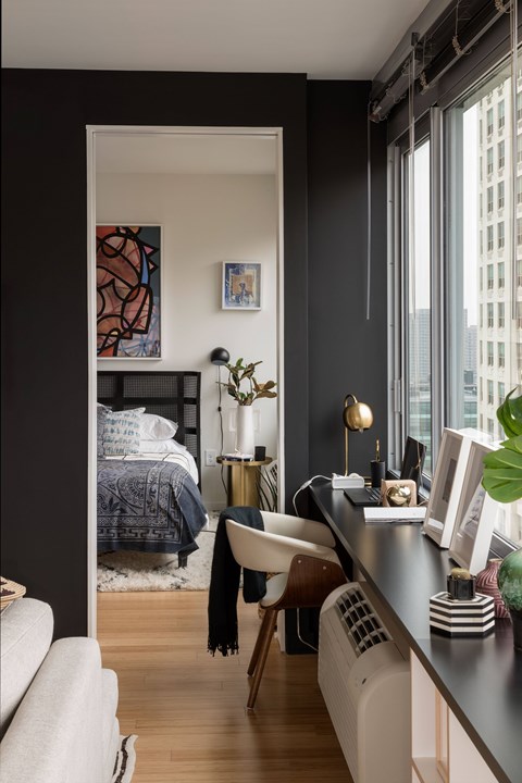 A black and white living room with a couch, chair, and a bed.