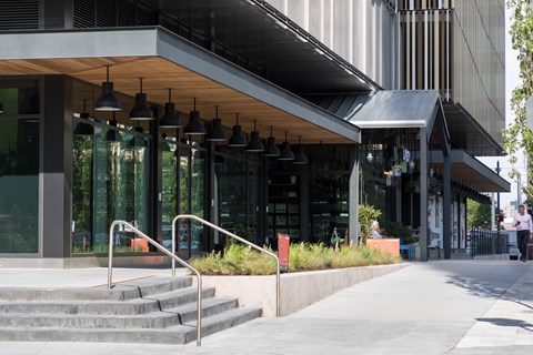 A modern building with a glass facade and a wooden roof.
