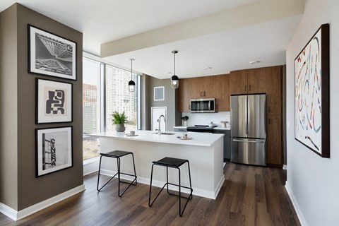 A kitchen with a white counter top and a refrigerator.