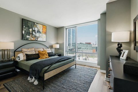 A bedroom with a large bed and a view of the city.