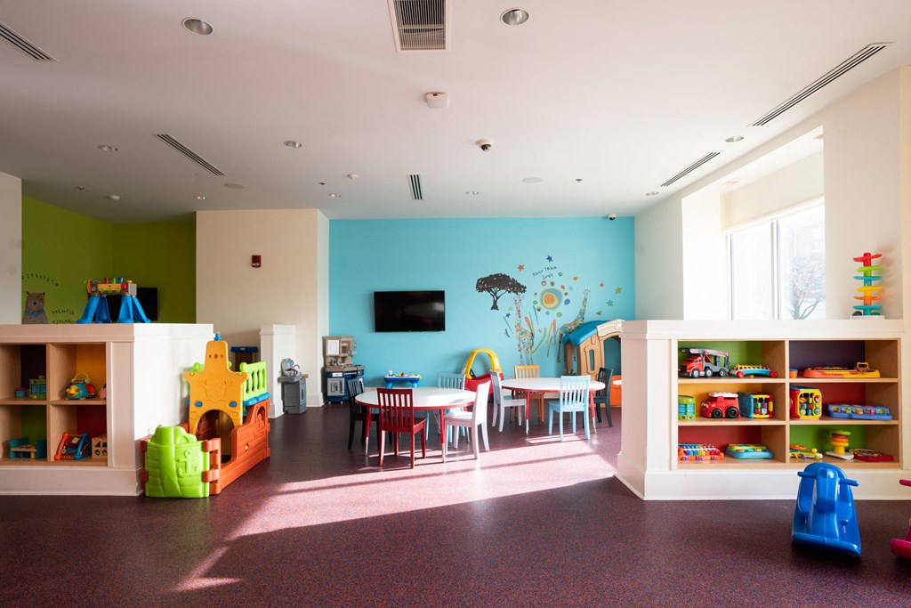 a play room with a table and chairs and a blue wall