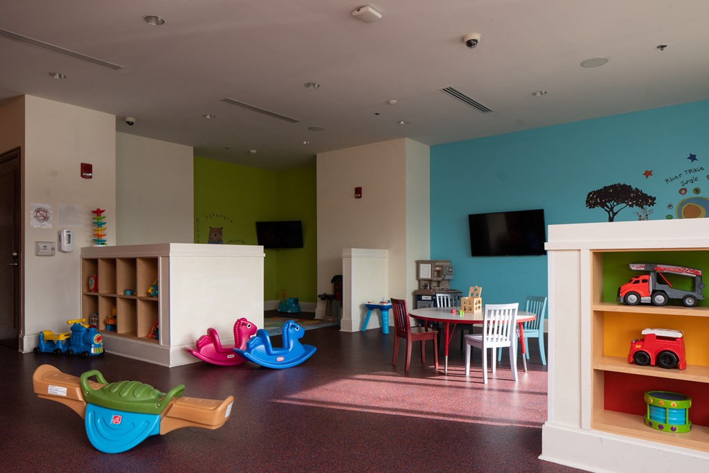 a childrens play room with toys and a table and chairs