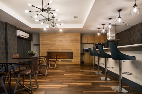 A modern dining room with a wooden floor and a fireplace.