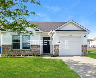 a white house with a white garage door and a green lawn