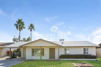 a home with a lawn and palm trees