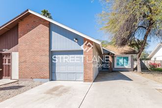 a large garage with a blue door and a brick house