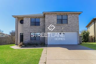 a brick house with a white garage door and the streetale homes logo on it