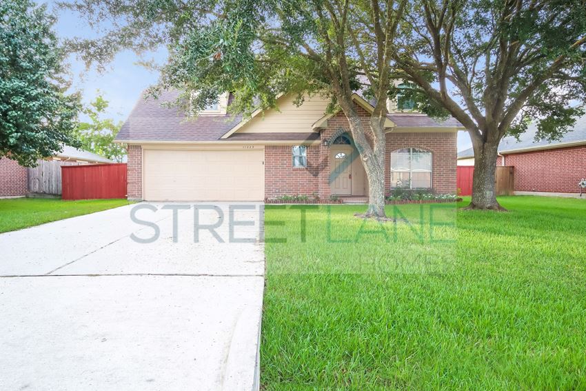 a small brick house with a tree in the yard