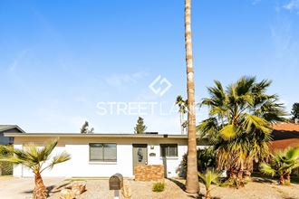 a home with palm trees in front of it and a mailbox