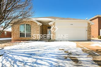 a home with a garage door in the snow